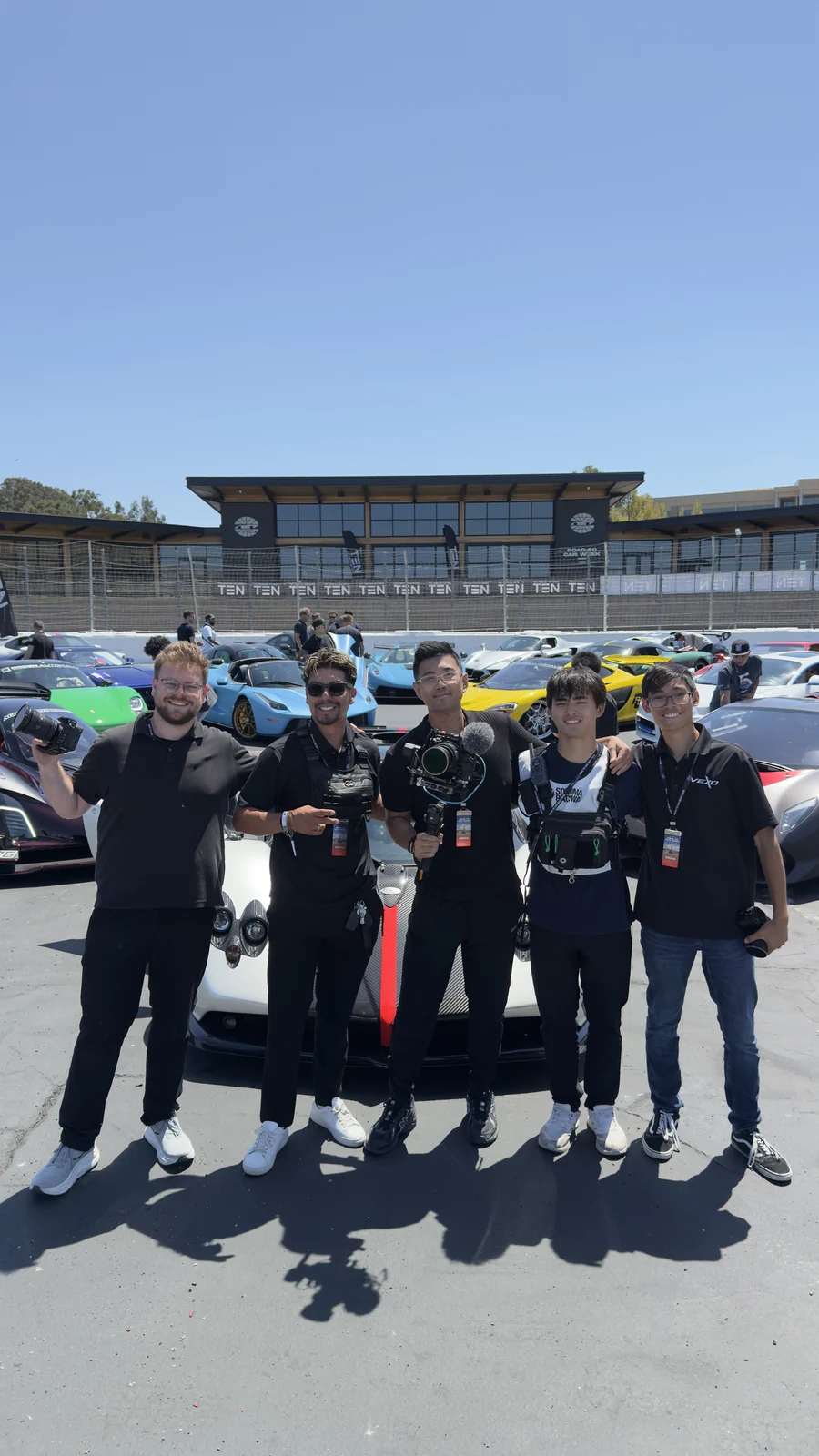 Max with the media team in front of a row of supercars at Sonoma Raceway
